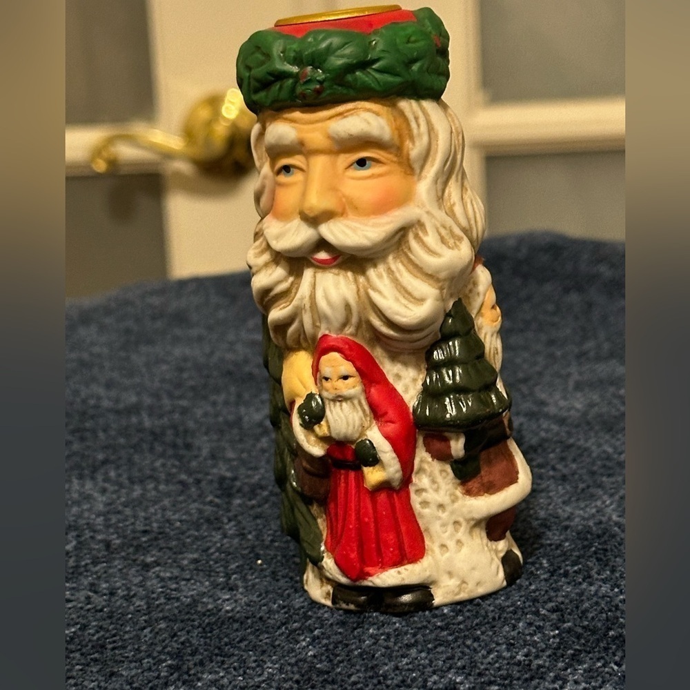 Set of 2 Santa candleholders. Each has smaller different smaller Santas.